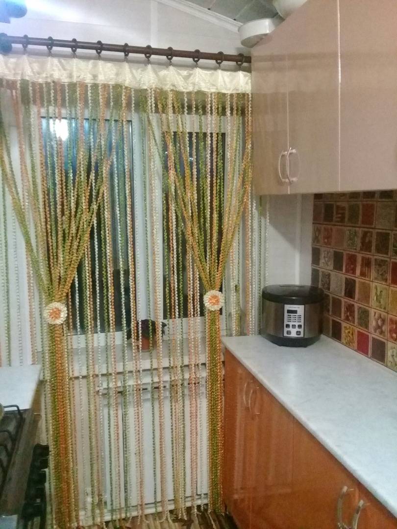 Современные нитяные шторы в интерьере кухни для оформления окна